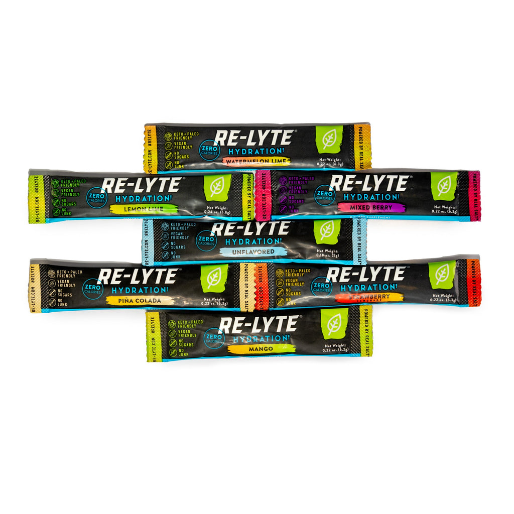 Seven flavors of individual Re-Lyte Hydration stick packs on white background.