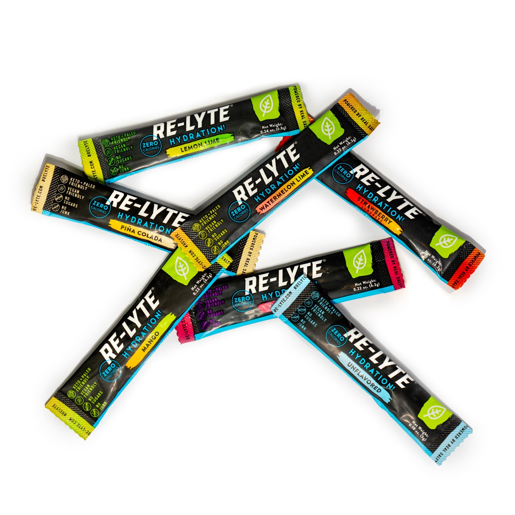 Seven flavors of individual Re-Lyte Hydration stick packs scattered on white background.
